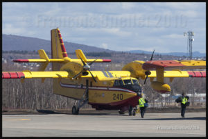 Des membres d'équipage marchent vers les avions-citernes CL-415 du Gouvernement du Québec; ils décolleront sous peu pour Fort McMurray en Alberta, pour aider à la lutte contre les feux de forêt (2016)
