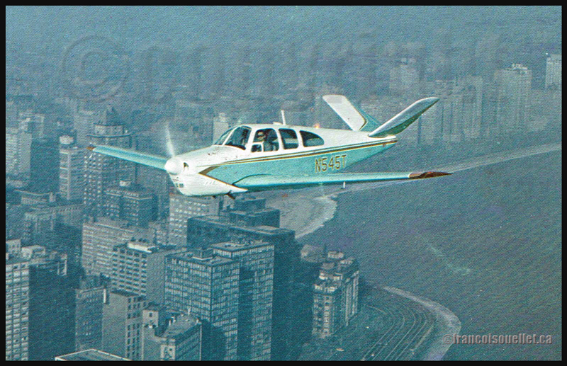 Beechcraft N35 Bonanza N545T volant au-dessus de Chicago durant les années où régnait la famille Daley (sur carte postale aviation)
