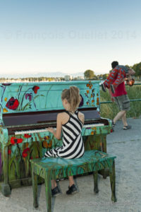 A young girl plays piano on Willows Beach in Victoria.