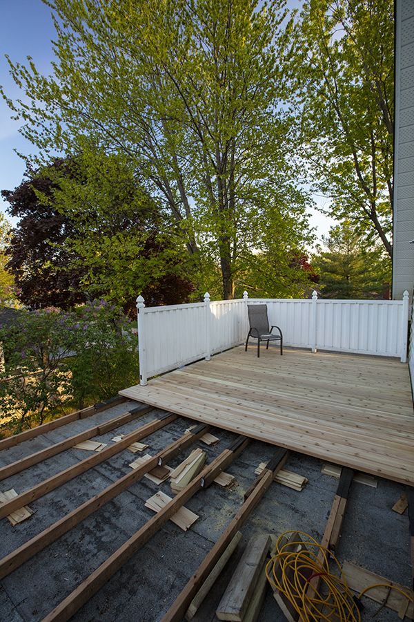 Le plancher en cèdre et les pans de clôture sont posés graduellement.
