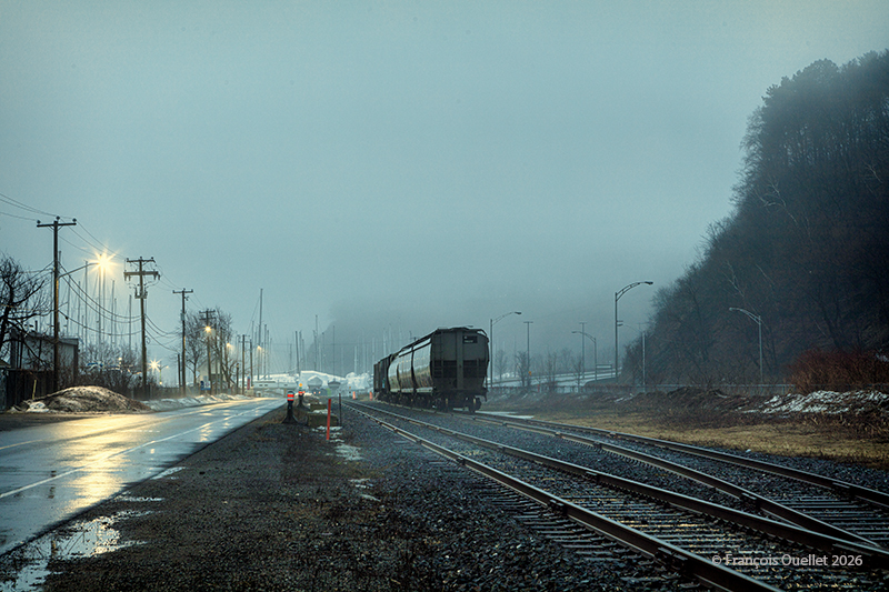 Wagons de train immobilisés sur les rails lors de brouillard à Québec au printemps 2026