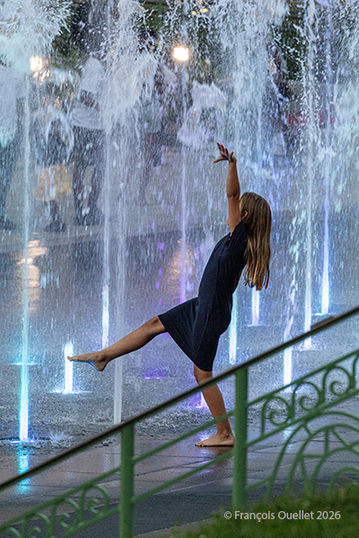 Une jeune fille danse dans les fontaines des jardins de l'hôtel-de-ville de Québec.