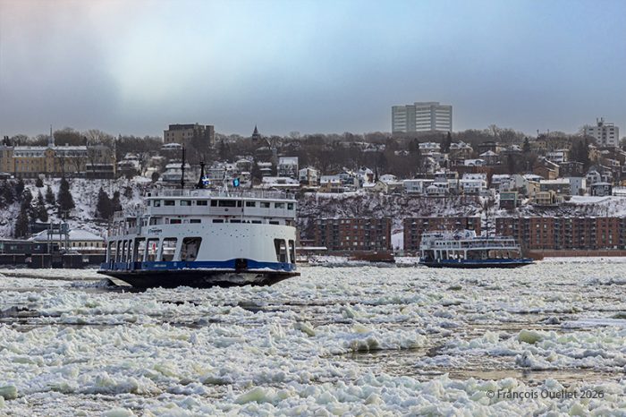 Deux traversiers au travail à travers les glaces devant Québec à l'hiver 2026.