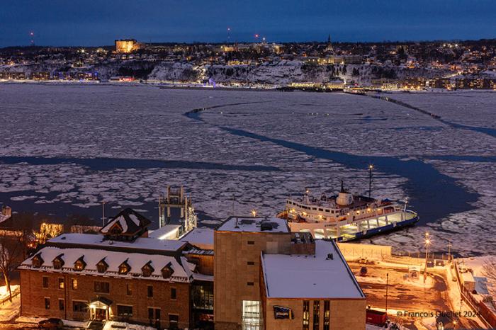 Traversier naviguant à travers les glaces du fleuve Saint-Laurent devant Québec hiver 2024.