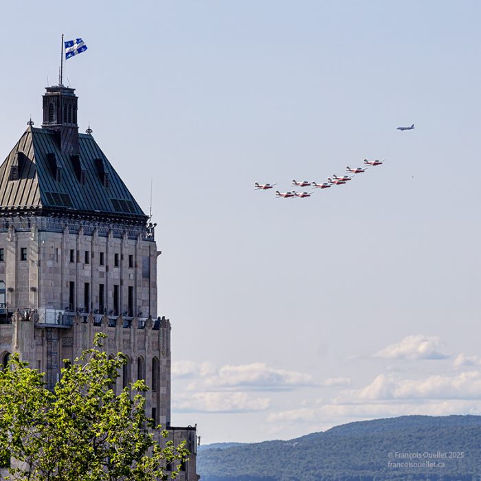 Le drapeau du Québec, l'édifice Price et les Snowbirds en vol à Québec.